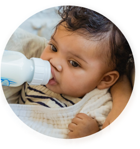 Baby drinking milk out of a bottle.